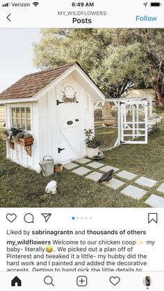 a small white shed sitting on top of a lush green field