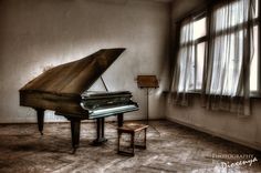 an old piano sitting in front of a window