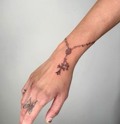 a woman's hand with a cross tattoo on it