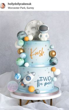 a three tiered cake decorated with space related items