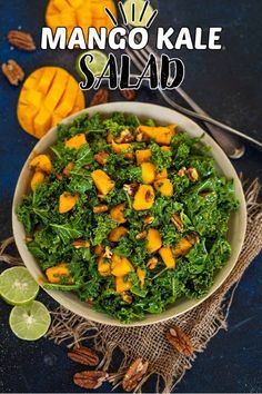 kale mango salad in a bowl with limes and nuts