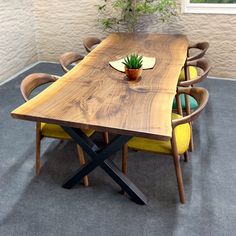 a wooden table with chairs around it and a potted plant on the table top