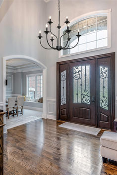 a large foyer with wooden floors and chandelier