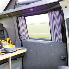 the interior of an rv with a bowl of fruit on the table next to it