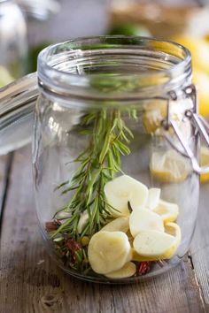 a glass jar filled with sliced bananas and herbs