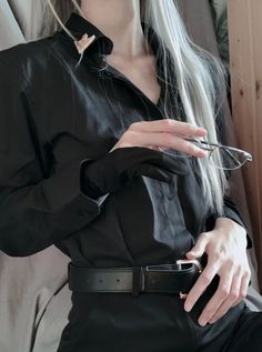 a woman with long white hair wearing glasses and a black shirt is posing for the camera