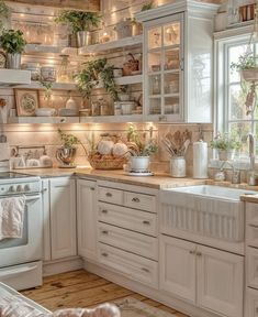 a kitchen filled with lots of white cupboards and counter top space next to a window