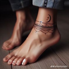 a woman's foot with a tattoo on it and the moon in the middle