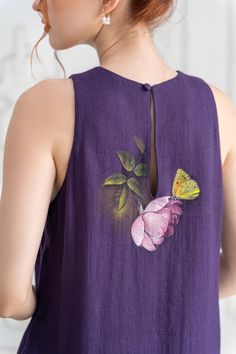 a woman wearing a purple top with a yellow butterfly on it's chest and back