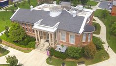 an aerial view of a brick building with a black roof and white trim on it