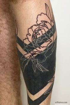 a man with a tattoo on his leg that has a black and white flower in it