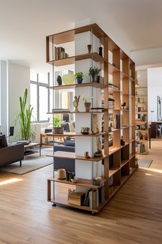 a living room filled with furniture and bookshelves next to a wooden floor covered in plants