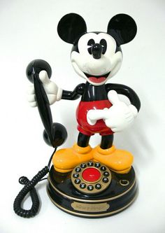 a mickey mouse telephone is shown with the receiver on it's side and hands up