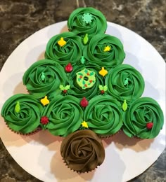 a christmas tree made out of cupcakes on a plate