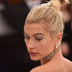 a woman wearing a headpiece with pearls on it