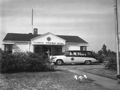 an old black and white photo of a car parked in front of the florida highway patrol