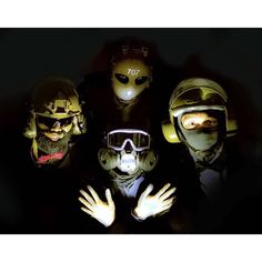 five people wearing gas masks and goggles with their hands in front of the camera