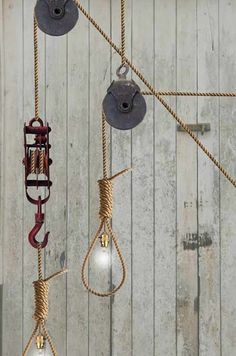 several light bulbs hanging from ropes on a wooden wall