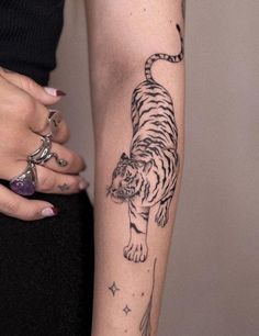 a woman's arm with a tiger tattoo on the left side of her body