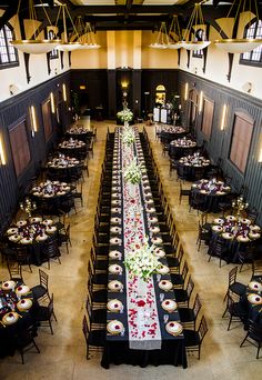 a long table with flowers on it is set up in the middle of a hall