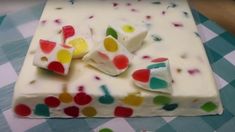 a cake with white frosting and multicolored hearts on it