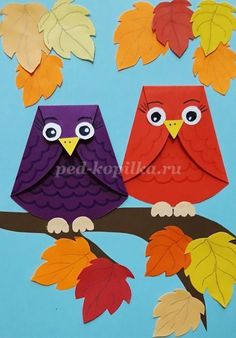 two owls are sitting on a branch with leaves