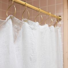 a shower curtain with gold rings hanging from it