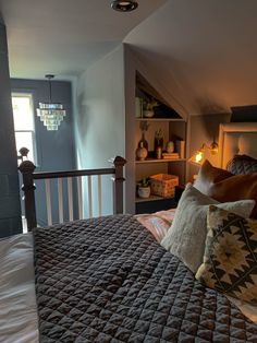 a bed with two pillows on top of it in a bedroom next to a window