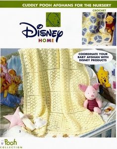 a crocheted blanket with winnie the pooh and pig on it, next to a stuffed animal