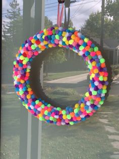 a colorful wreath hanging from the side of a window