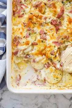 a casserole dish with ham and cheese in it on a marble counter top