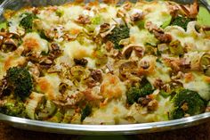 a casserole dish with broccoli, mushrooms and cheese in it on a table