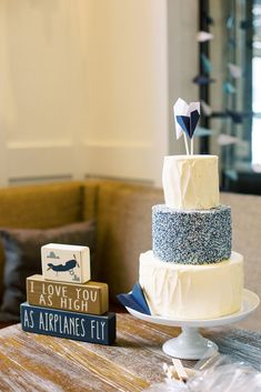 a three tiered cake sitting on top of a table next to two small blocks