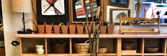 a wooden shelf filled with lots of art and craft supplies on top of a hard wood floor