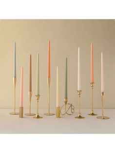 there are many different colored candles in the same row and each has a candle holder