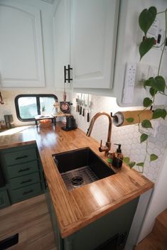 a kitchen with wooden counter tops and green cabinets in front of the sink is shown