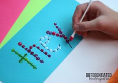 a child's hand writing the word love on a piece of paper