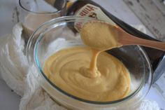 a glass bowl filled with batter next to a bottle of peanut butter and a wooden spoon