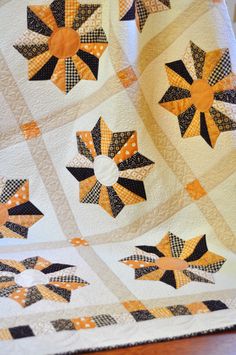 an orange and black quilt on top of a wooden table