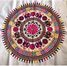 an intricately designed piece of cloth with flowers and leaves on the center, in multicolored colors