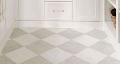 a white kitchen with checkered flooring and cabinets