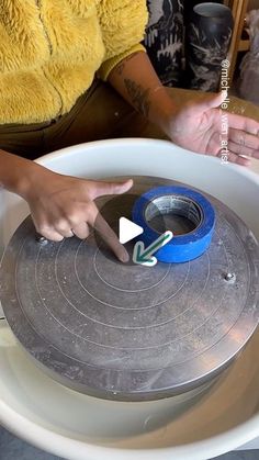 a woman is using scissors to cut the edge of a piece of paper in a bowl