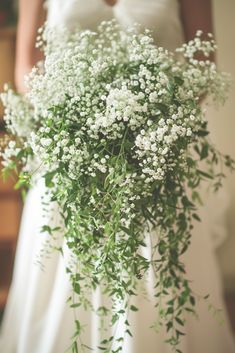 a bride holding a bouquet of baby's breath