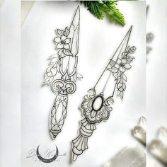 two scissors with flowers on them sitting next to each other in front of a piece of paper