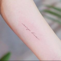 a woman's arm with the word love written in cursive writing on it