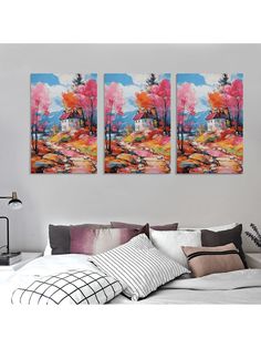 two paintings hanging on the wall above a bed