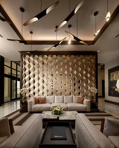 a living room with couches, tables and lamps on the ceiling in front of a wooden paneled wall