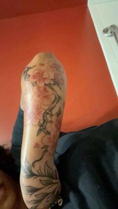 a woman laying on the floor with her leg tattooed