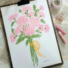 a drawing of pink flowers in a vase on top of an open book next to crayons and markers