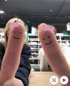 two people with faces drawn on their fingers